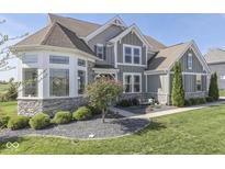 Attractive two-story home featuring stone accents, meticulous landscaping, and a cozy front bench at 1051 Margate Dr, Greenwood, IN 46143