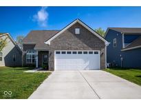Charming home featuring a gray brick facade, a two-car garage, and a well-manicured lawn at 10538 Rose Mill Dr, Lawrence, IN 46235