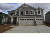 A two-story home with gray siding, stone accents, a two-car garage and a concrete driveway at 12417 Fresh Stock Dr, Noblesville, IN 46060