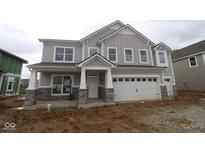 New two-story home with gray siding, stone accents, covered porch, and two-car garage awaiting its landscaping at 12417 Fresh Stock Dr, Noblesville, IN 46060