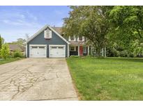 Charming two-story home with a well-manicured lawn and two-car garage at 12449 Huntington Dr, Indianapolis, IN 46229