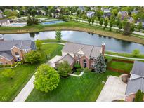 Stunning aerial view of home with large yard, pond, pool, and tennis courts in desirable community at 14145 Charity Chase Cir, Carmel, IN 46074