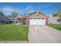 Charming single-Gathering home featuring a manicured lawn, brick accents, and a two-car garage at 18771 Northridge Dr, Noblesville, IN 46060