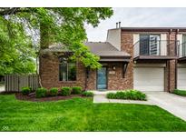 Charming brick townhome featuring well-maintained landscaping and inviting curb appeal at 354 E Arch St, Indianapolis, IN 46202