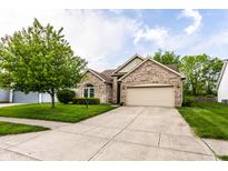 Charming brick home featuring an attached two-car garage and a well-manicured front yard with mature landscaping at 5845 Arrowleaf Ln, Carmel, IN 46033