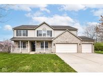 Charming two-story home with a brick facade, a three-car garage, covered porch, and a well-manicured lawn at 6507 Tram Ct, Indianapolis, IN 46260