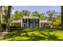 Charming two-story home with a manicured lawn and a classic black fence at 654 E 79Th St, Indianapolis, IN 46240