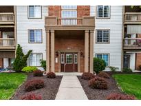 Inviting condo entrance featuring a covered doorway, well-maintained landscaping, and manicured shrubbery at 8911 Hunters Creek Dr # 311, Indianapolis, IN 46227