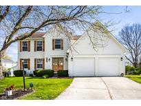 Charming two-story home with white brick, wood shutters, an attached two-car garage, and a well-manicured lawn at 8966 Wooster Ct, Fishers, IN 46038