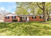 Charming single-story brick home featuring a well-manicured lawn and mature trees at 11359 Peacock Dr, Indianapolis, IN 46236