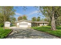 Charming ranch-style home with stone accents, a spacious driveway, and a well-manicured lawn at 11415 Central E Dr, Carmel, IN 46032