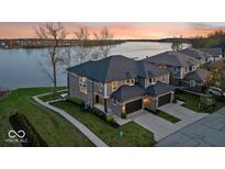 A luxury two-story home with a two car garage, brick accents, professional landscaping, and waterfront views at 13797 E Southshore Dr, Fishers, IN 46037