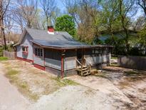 Charming home with a screened porch, complemented by mature trees and a welcoming gravel driveway at 1410 E 75Th St, Indianapolis, IN 46240