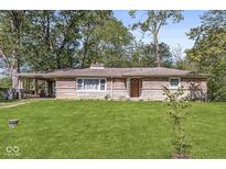 Charming single-story home featuring stone accents, a covered porch, and a spacious front yard at 1710 S Butler Ave, Indianapolis, IN 46203