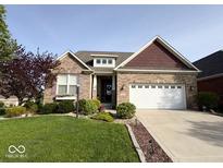 Charming brick home with a well-manicured lawn, landscaping and a two-car garage in a suburban neighborhood at 18756 Brookston Ln, Noblesville, IN 46062