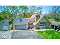 Charming home with stone chimney, two-car garage, and well-manicured lawn, perfect for suburban living at 260 17Th St, Columbus, IN 47201
