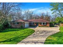 Charming brick home with a well-manicured lawn and a long driveway on a sunny day at 360 Hope Ct, Greenwood, IN 46142