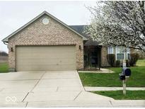 Charming brick home featuring an attached two-car garage and a well-manicured lawn at 9671 Trail Dr, Avon, IN 46123
