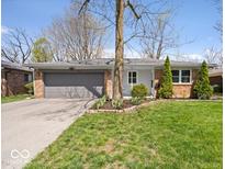 Charming single-story brick home with a well-maintained lawn, mature trees, and an attached two-car garage at 9814 E 17Th St, Indianapolis, IN 46229