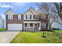 Charming brick two-story home with a well-manicured lawn and inviting front porch at 10883 Balfour Dr, Noblesville, IN 46060