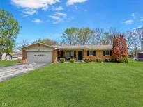 Charming brick ranch-style home with a well-manicured lawn and attached two-car garage at 1331 Dunlap Ave, Indianapolis, IN 46241