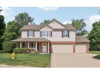 Charming two-story home with brick accents, shutters, and a well-maintained front yard and a two car garage at 13562 Silver Spur, Carmel, IN 46032