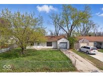 Charming single-story home featuring an attached garage and a well-maintained lawn at 2219 N Webster Ave, Indianapolis, IN 46219