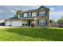 Charming two-story home with a well-manicured lawn, two-car garage, and decorative blue shutters at 326 Virginia St, Fortville, IN 46040