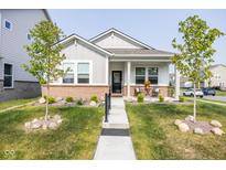 Inviting single-story home featuring manicured landscaping, a covered front porch, and a welcoming entrance at 360 Lincoln W Cir, Fortville, IN 46040