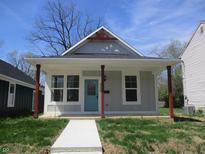 Charming home featuring a cozy front porch with red wood pillars and light blue front door at 4234 Kingsley Dr, Indianapolis, IN 46205
