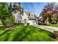 Charming two-story home featuring a manicured lawn, attached garage, and lovely curb appeal on a sunny day at 5034 N Illinois St, Indianapolis, IN 46208