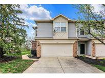 Two-story home showcasing neutral siding, brick accents, a two-car garage and a well-manicured front lawn at 5453 Nighthawk Way, Indianapolis, IN 46254