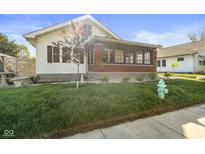 Charming home with well-maintained lawn, brick enclosed porch and tasteful landscaping at 617 Carlyle Pl, Indianapolis, IN 46201