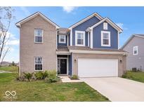 Charming two-story home with blue and brick exterior, complemented by a well-manicured lawn and an attached two-car garage at 6536 W Shoreline Ct, Greenfield, IN 46140