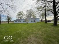 Spacious single-story home with a large yard and mature trees on a sunny day at 7765 N 225 W, Lebanon, IN 46052
