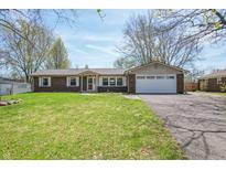 Charming single-story brick home featuring an attached two-car garage and a well-maintained front lawn at 8051 Sycamore Springs Trl, Indianapolis, IN 46239
