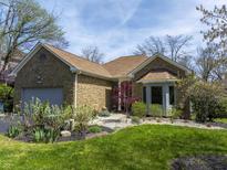 Charming stone home featuring an attached garage and beautifully landscaped front yard at 8069 Middle Bay Ln, Indianapolis, IN 46236