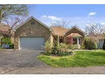 Charming stone home featuring an attached garage and beautifully landscaped front yard at 8069 Middle Bay Ln, Indianapolis, IN 46236
