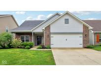 Charming home featuring a two-car garage, brick accents, and a well-manicured lawn at 963 Kempson Ct, Westfield, IN 46074