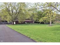 Charming single-story brick home with a lush green front yard and mature trees along the driveway at 1000 Riverview Dr, Martinsville, IN 46151