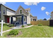 Charming two-story home featuring a well-maintained lawn, blue accents, and a welcoming front porch at 2005 Carrollton Ave, Indianapolis, IN 46202