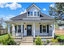 Charming two-story home with white siding, black accents, covered front porch and well maintained landscaping at 222 Raines St, Plainfield, IN 46168