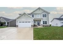 Charming two-story home with a well-manicured lawn, attached two-car garage, and a welcoming front porch at 3235 Myrtle Dr, Lapel, IN 46051