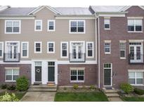 Inviting townhome featuring a mix of brick and siding, complemented by black trim and a charming balcony at 360 Neuman Way, Carmel, IN 46032