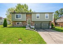 Charming split-level home with a well-manicured lawn and attached two-car garage at 3615 Dawnwood Dr, Indianapolis, IN 46227