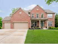 Beautiful brick two-story home with a well-manicured lawn and attached three car garage at 5698 Kenderly Ct, Carmel, IN 46033