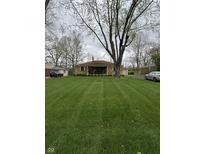 Charming brick home features a covered front porch and a beautifully manicured lawn, perfect for outdoor enjoyment at 5774 N Ewing St, Indianapolis, IN 46220