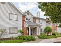 Inviting condo exterior featuring stylish siding, brick accents, and manicured landscaping at 8410 Glenwillow Ln # 208, Indianapolis, IN 46278