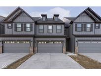 Modern townhome exterior showcasing stylish gray siding, dark trim, and convenient attached two-car garages at 9734 Behner Dr, Fishers, IN 46250