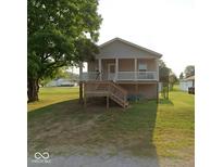Charming home featuring a welcoming front porch, complemented by a well-maintained lawn and mature trees at 1040 Iowa St, Columbus, IN 47201